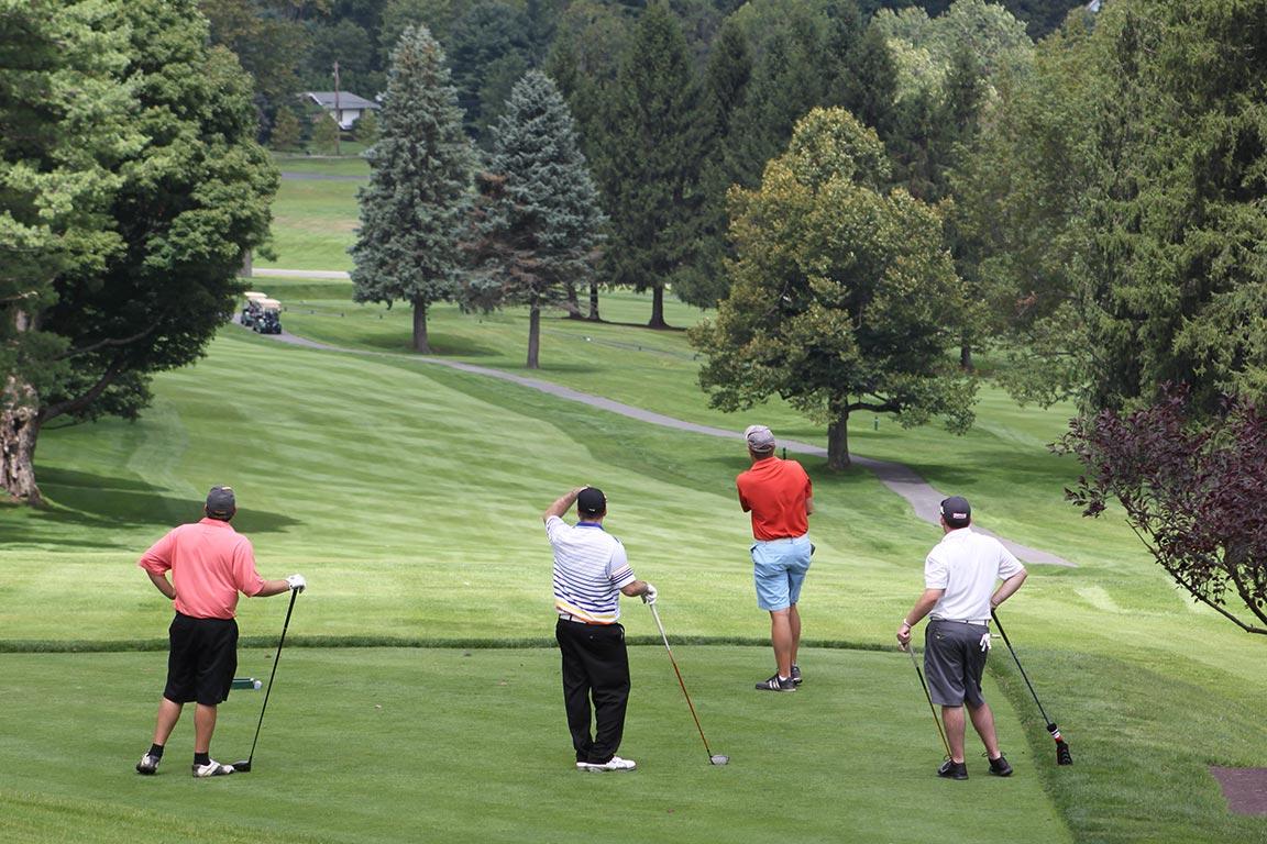 Four golfers look down the fareway